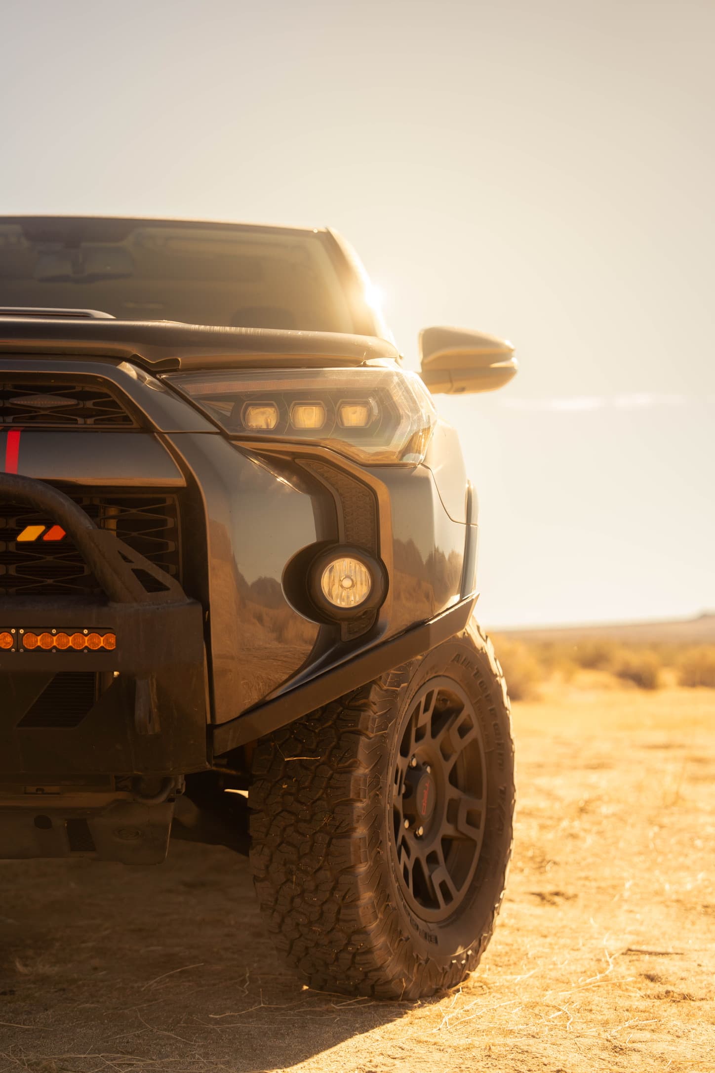 An off-road vehicle photographed in golden desert light